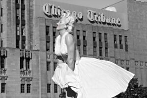 Black and white photo of Marilyn Monroe statue in front of Chicago Tribune building.