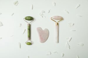 Stylish jade rollers and gua sha tools arranged on a white background, ideal for skincare routines.