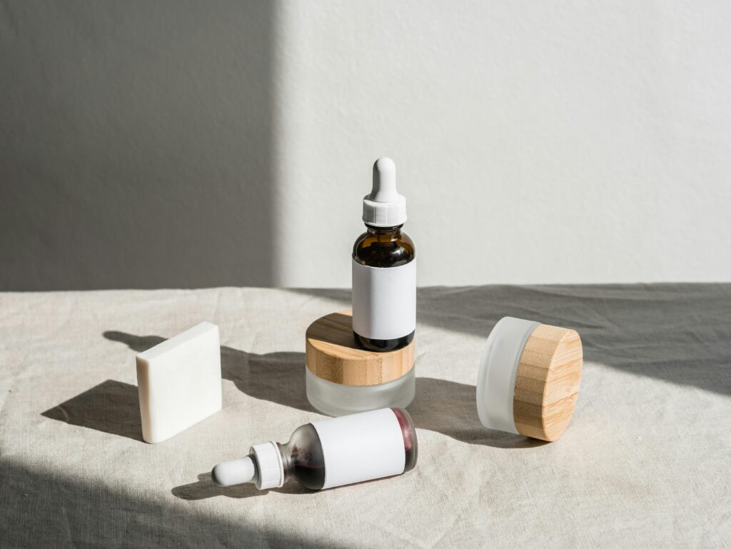 A minimalist still life of cosmetic bottles and jars with natural lighting, emphasizing beauty product design.